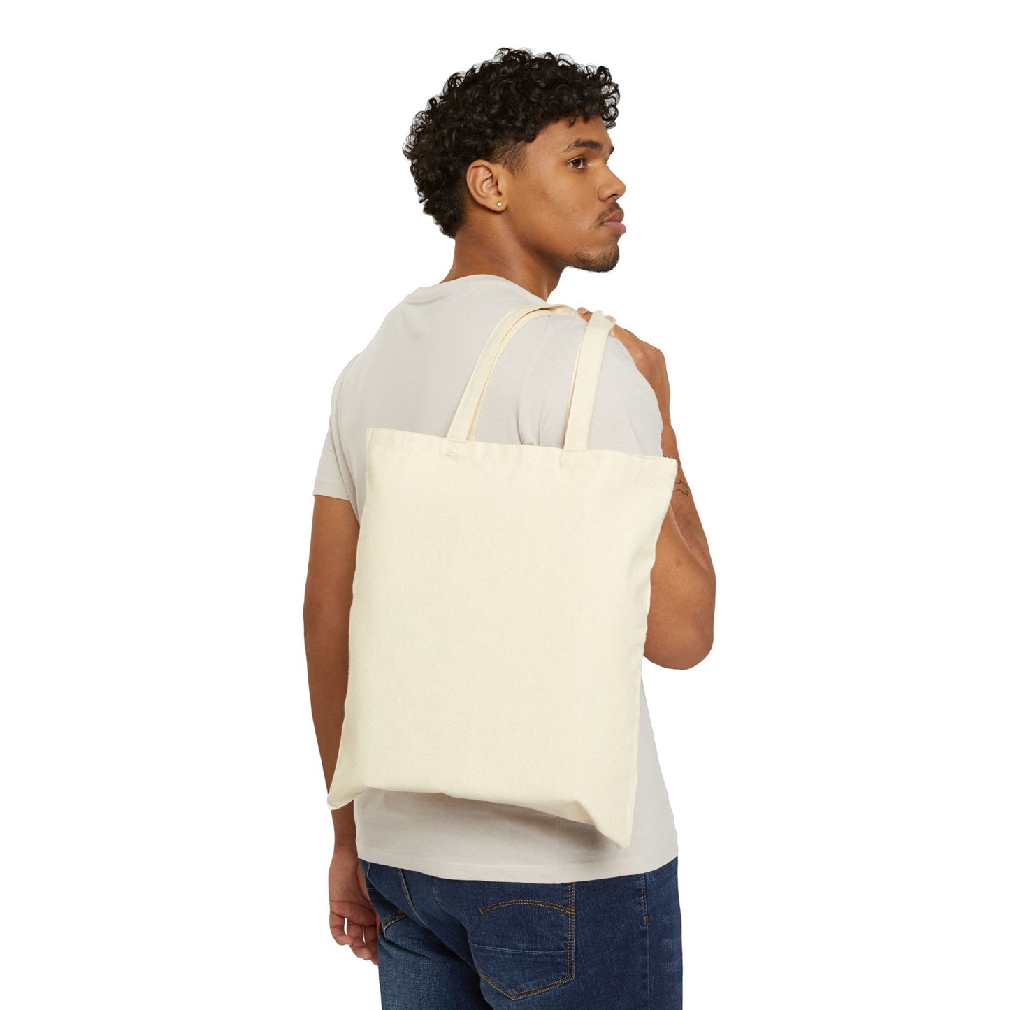 Man carrying a plain cream canvas Revolutionary by Nature tote bag over shoulder by Printify