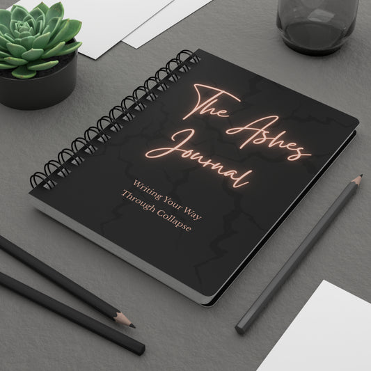 The Ashes Journal spiral notebook on gray desk with pencils and plant transformational journaling guide